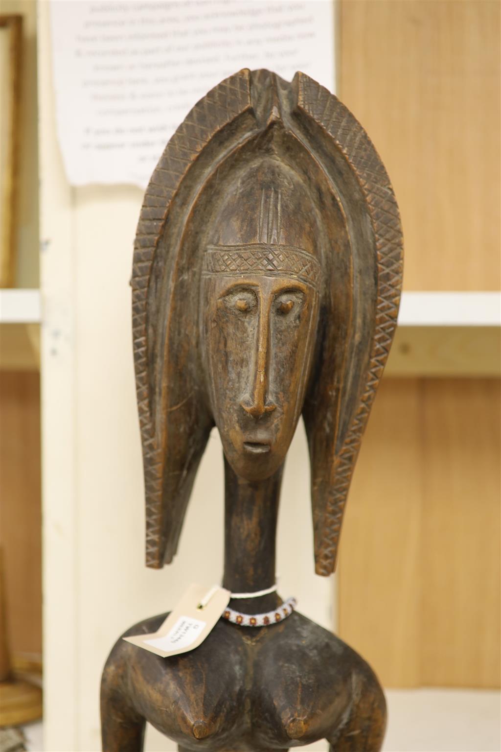 Ethnographia, a collection of various wood carvings, including an African tall female fertility figure,